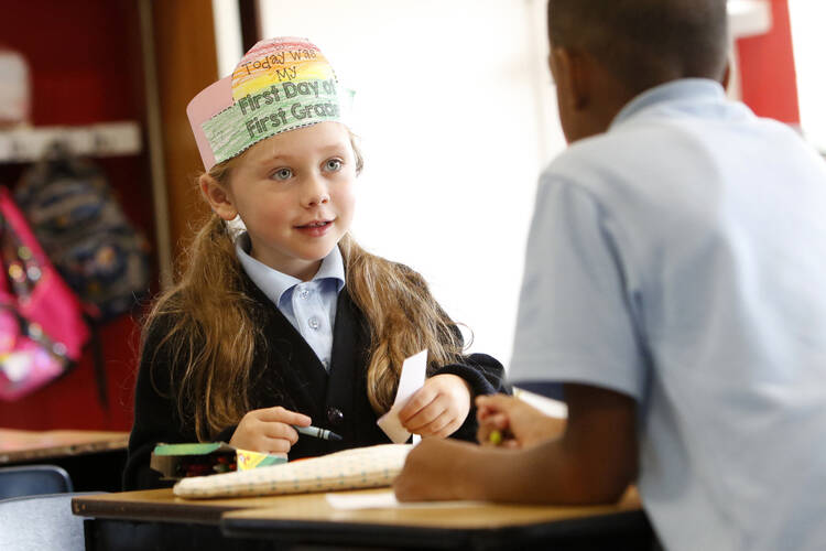 First-grader Grace Burns chats with a classmate while working on a project on the first day of classes at Our Lady Queen of Apostles Regional School in Center Moriches, N.Y., Sept. 4, 2019. (CNS photo/Gregory A. Shemitz)