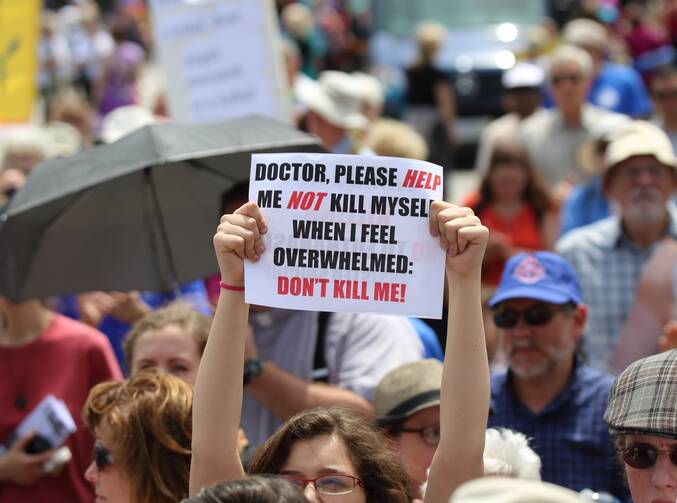 A woman holds up a sign during a rally against assisted suicide in 2016 on Parliament Hill in Ottawa, Ontario. (CNS photo/Art Babych)