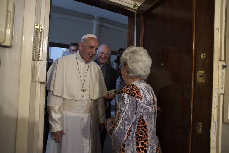 Pope Francis greets a resident as he arrives to give an Easter blessing to a home in a public housing complex in Ostia, a Rome suburb on the Mediterranean Sea, on May 19. (CNS photo/L'Osservatore Romano)