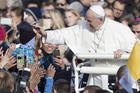 Pope Francis caresses a child as he arrives to celebrate a Mass in Freedom Square, in Tallinn, Estonia, Tuesday, Sept. 25, 2018. (AP Photo/Mindaugas Kulbis)