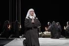 Nun kneeling on stage